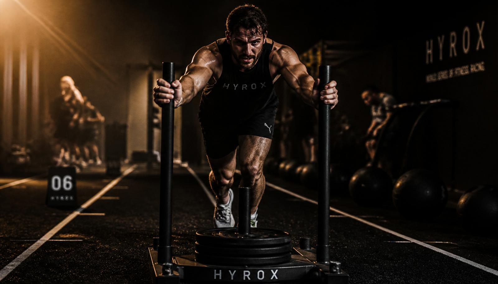 Atleet duwt een zware sled tijdens een HYROX-training bij Hart Performance Club